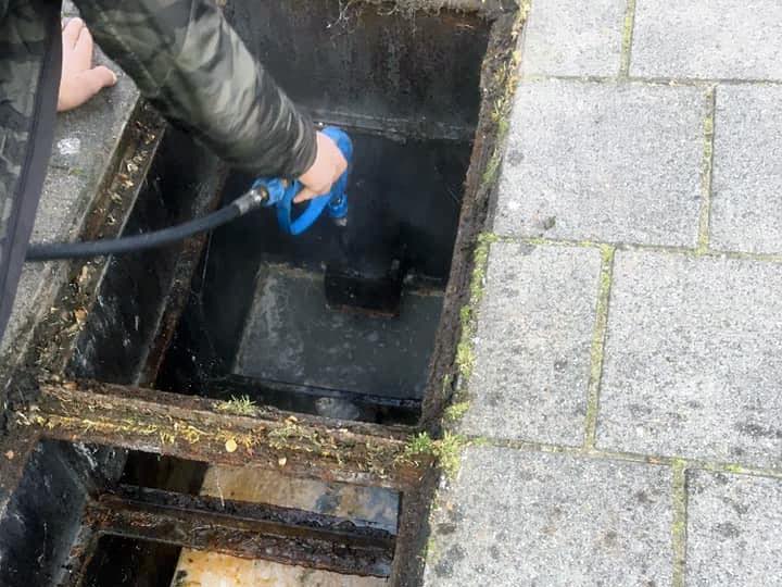 Verstopte rioolput cleaningservice rottiné is bezig met doorspuiten.